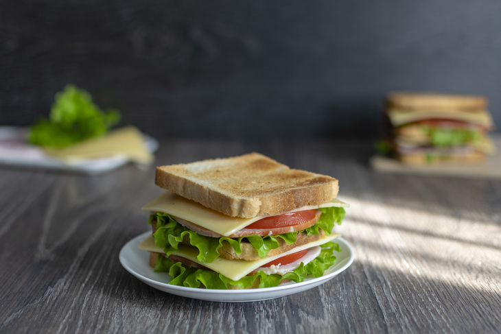 Are there sandwiches on the table. Сэндвич на тарелке. Сэндвич на чиабатте на тарелке. Квадратный сэндвич на темной тарелке. Сэндвич на тарелке база фото.